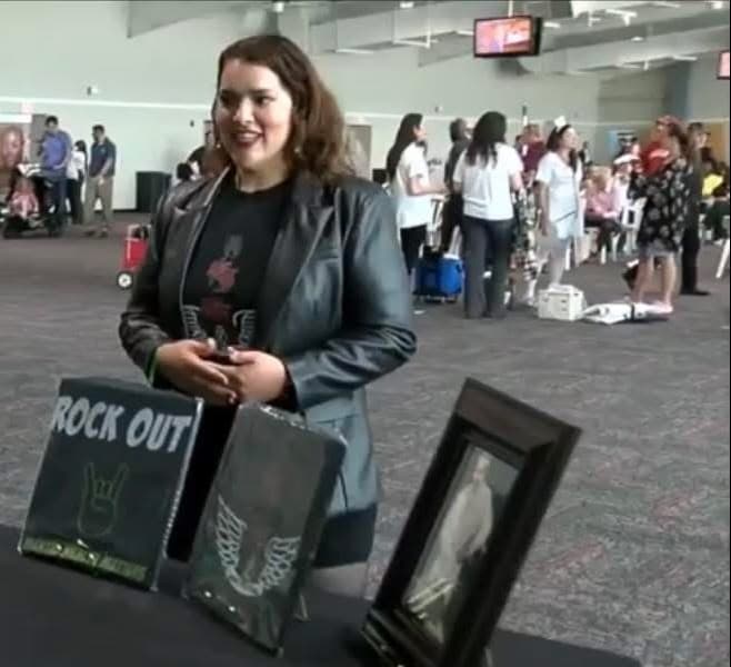 Miriam pitching her merchandise at a table, filmed by WRTV