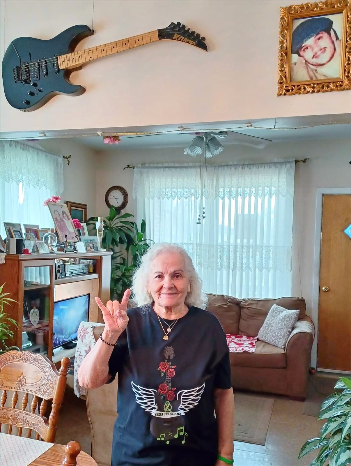 An older woman at home in a winged-guitar tee