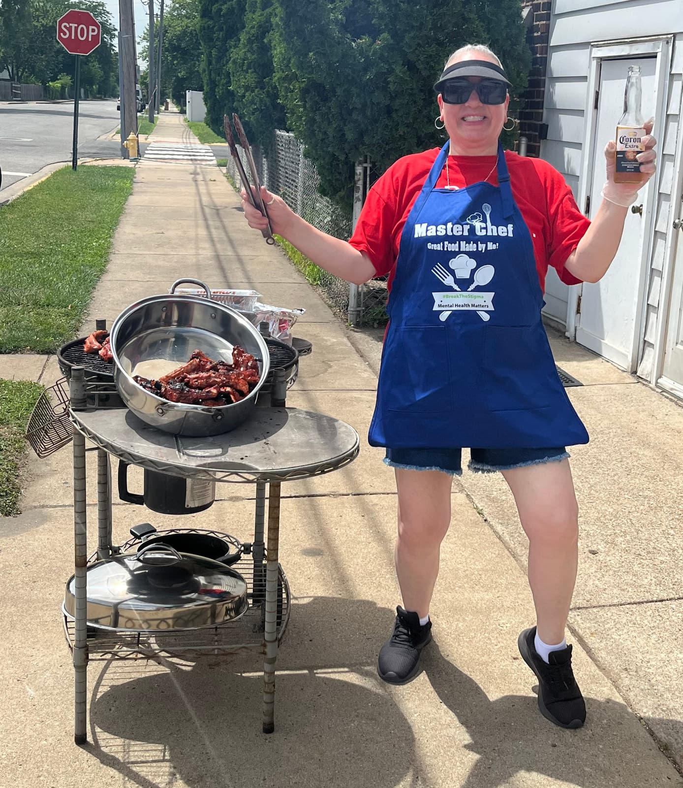 A supporter in a red apron at the grill